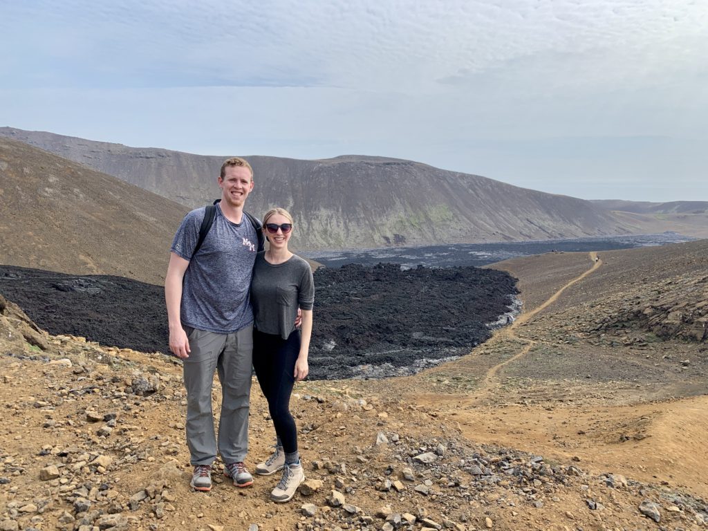 Mark and Amanda with fresh black lava behind them from the erupting volcano in Iceland