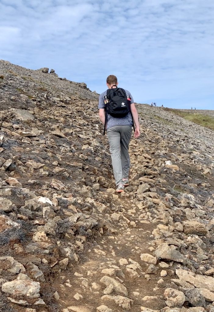 Mark climbing a steep incline covered in rocks