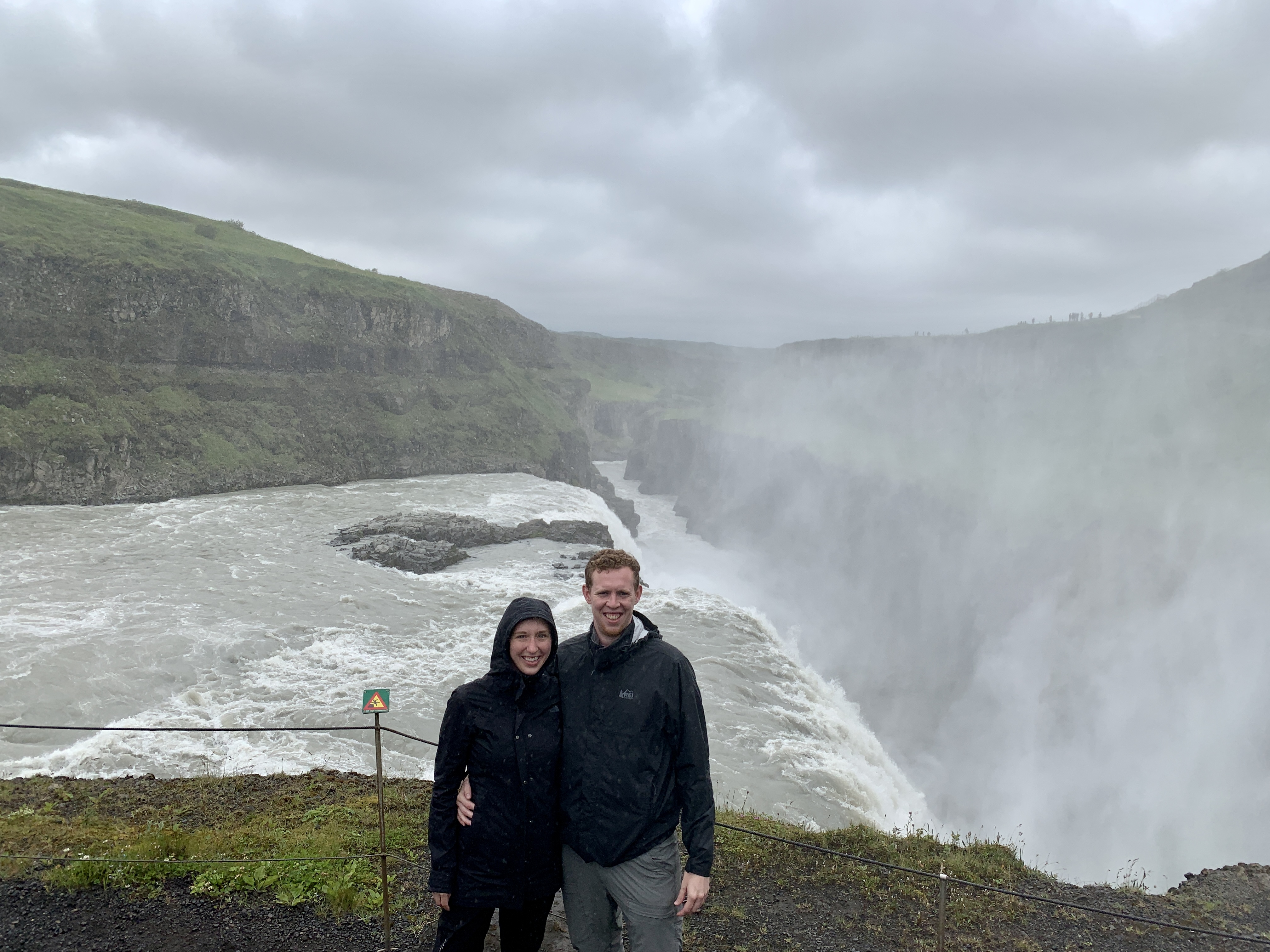 Amanda & Mark next to the steepest part of the Gullfoss Waterfall, surrounded by mist. 